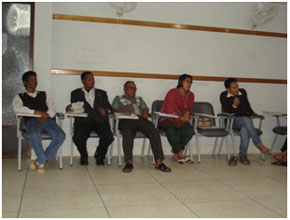 the banner of the program; (right) a partial view of the participants including Robindranath Soren 